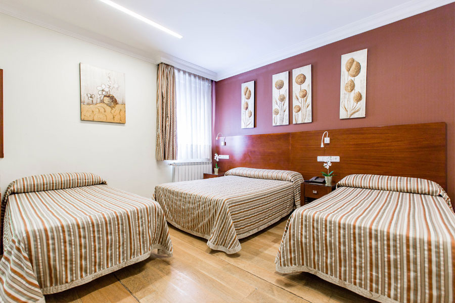 Habitación triple Hostal Abadía Madrid centro con tres camas dobles